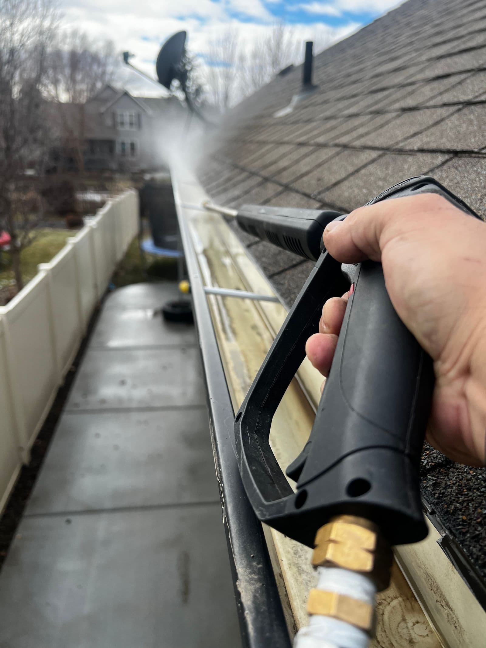 Gutter line being flushed clean along a shingle roof