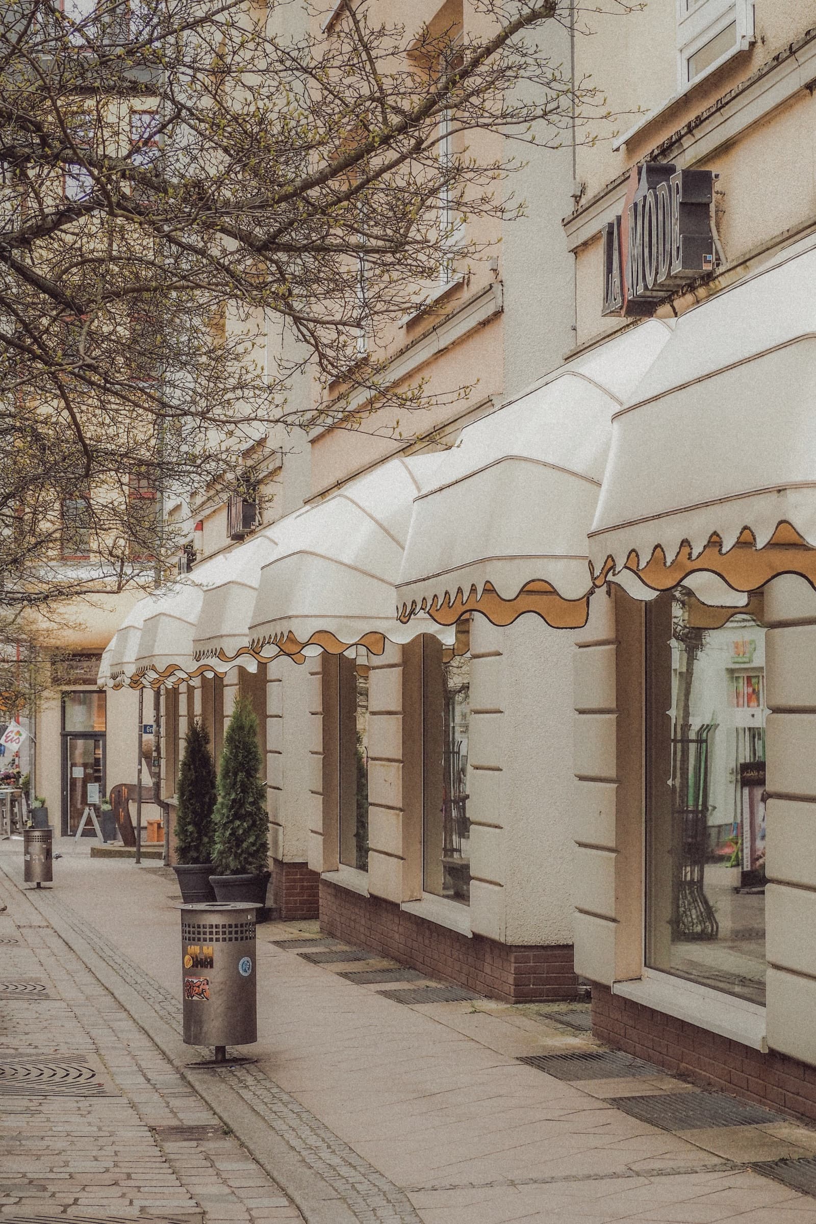 Storefronts with clean white awnings along a walkable street