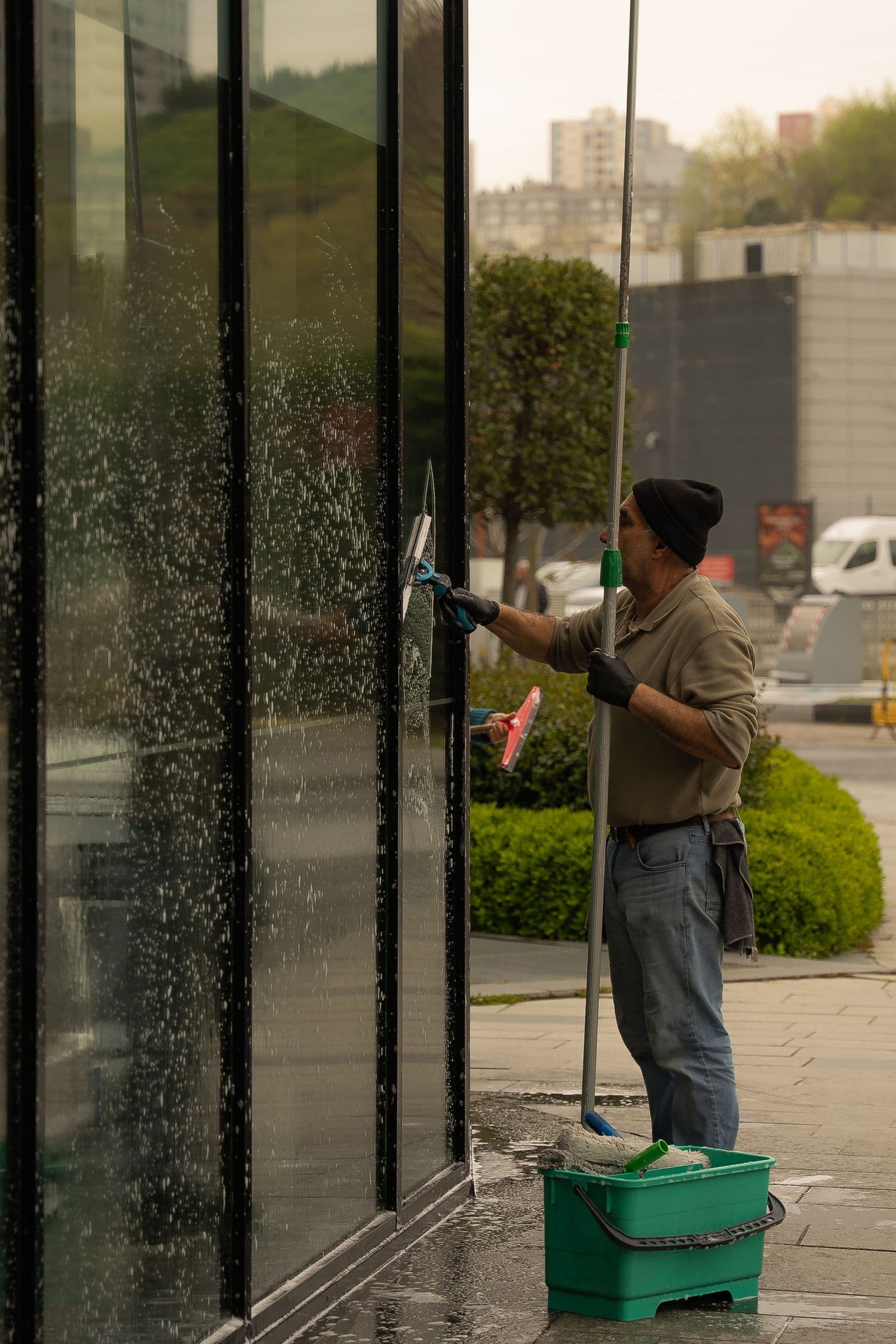 Professional window cleaner squeegeeing a glass facade